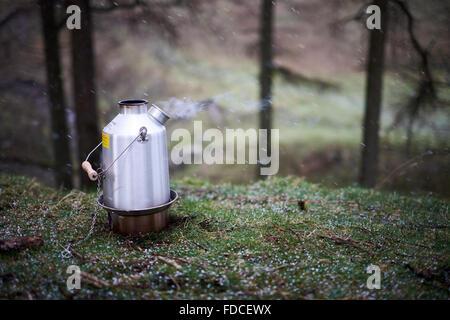 Ein Kelly Kettle angezündet und brennen mit Dampf. Schuss im Schnee / Hagel / winter Stockfoto