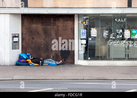 Vernagelten Geschäfte und ein Obdachloser auf Western Road, der wichtigsten Einkaufsstraße im Stadtzentrum von Brighton. Stockfoto
