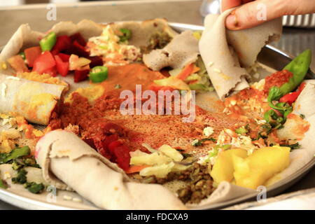 Typische äthiopische Injera Speisen zubereitet von Teff Getreide - Eragrostis Tef-mit Gemüse-Tomaten-Kartoffeln-Fleisch. Debre Birhan-Äthiopien. Stockfoto