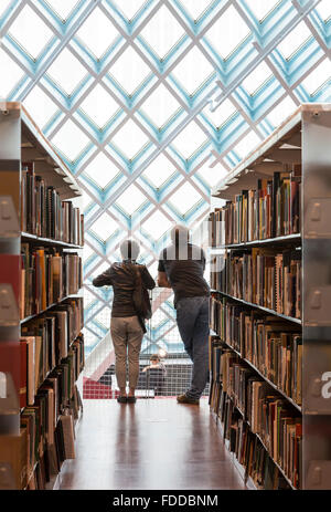 Paar auf der Suche an Fenstern die moderne Seattle Central Library, entworfen von den Architekten Rem Koolhaas und Joshua Prince-Ramus Stockfoto