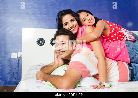 3 Personen Kind und Eltern Tochter Schlafzimmer Liegend Entspannung Stockfoto