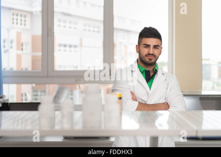 Porträt eines arabischen Studenten In einem Chemielabor lächelnd und Blick In die Kamera mit gefalteten Händen Stockfoto