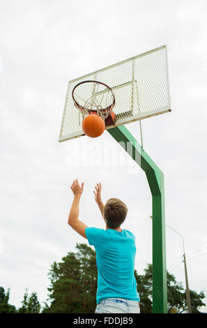 junger Mann im Freien spielen basketball Stockfoto