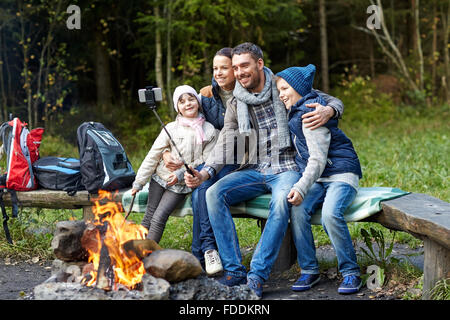 Familie mit Smartphone unter Selfie nahe am Lagerfeuer Stockfoto