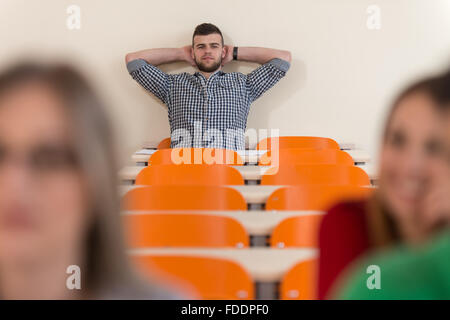 Junge Gruppe von attraktiven Jugendlichen Studenten In einem College-Klassenzimmer sitzen an einem Tisch - Lehren Stockfoto