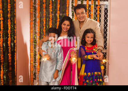 4 Personen Eltern und Kinder Diwali Feste feiern Holding Feuerwerkskörper Stockfoto