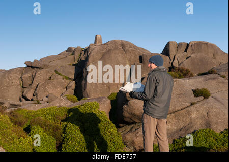 Sonnenschein und blauer Himmel - steht der Mensch mit Artillerie-Übersicht Diagramm in der Nähe der trigonometrischen Punkt auf dem felsigen Gipfel des Simons Sitz, North Yorkshire, England, GB, UK. Stockfoto