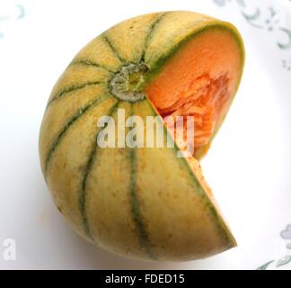 Charentais Melone, Cucumis Melo var. Cantapulensis, kugelförmigen Früchte mit gelben Orangenhaut, grüne Streifen, gelbe süße Fleisch Stockfoto