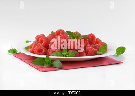 Teller mit frischen Himbeeren auf rotem Papierserviette Stockfoto