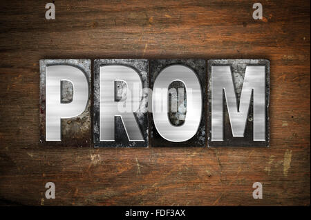 Das Wort "Prom" in Vintage Metall Buchdruck Typ auf einem alten hölzernen Hintergrund geschrieben. Stockfoto