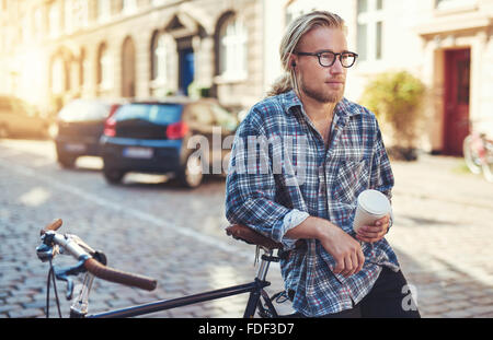 Nachdenklicher Mann in der Stadt sitzt auf seinem Fahrrad. City-lifestyle Stockfoto