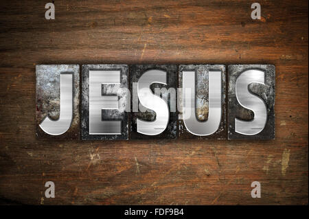 Das Wort "Jesus" in Vintage Metall Buchdruck Typ auf einem alten hölzernen Hintergrund geschrieben. Stockfoto