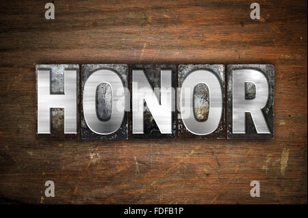 Das Wort "Ehre" in Vintage Metall Buchdruck Typ auf einem alten hölzernen Hintergrund geschrieben. Stockfoto