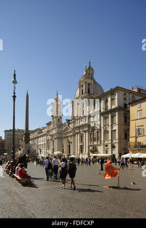 Touristen auf der Piazza Navona, Rom, Italien mit dem 17. Jahrhundert barocke Chiesa di Sant'Agnese in Agone hinter. Stockfoto