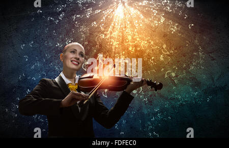 Bild des jungen lächelnd Geschäftsfrau, Geige zu spielen Stockfoto