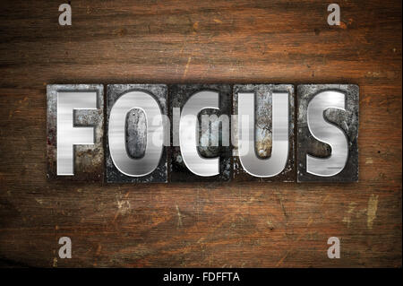 Das Wort 'Focus' in Vintage Metall Buchdruck Typ auf einem alten hölzernen Hintergrund geschrieben. Stockfoto