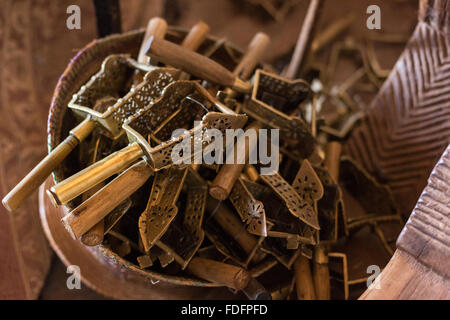 Ein geflochtener Korb hält eine Anzahl von Sistren in Gottesdiensten, im Inneren eine Felsenkirche in Wukro, Äthiopien verwendet. Der Griff eines von ihnen ist eine große Kugel Messinggehäuse. Stockfoto