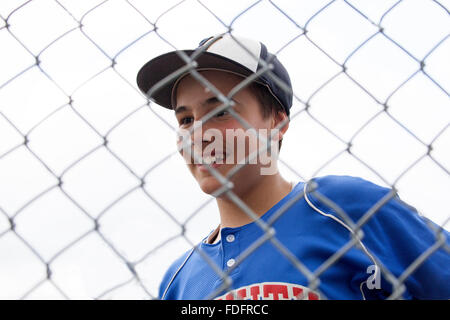 Glücklich kleine Liga Baseball-Spieler 12 Jahre in Uniform hinter Rücklaufsperre. St Paul Minnesota MN USA Stockfoto