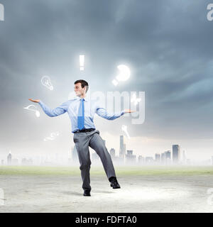 Junger Geschäftsmann Jonglieren mit konzeptionellen Symbole Hintergrund Stadt Stockfoto