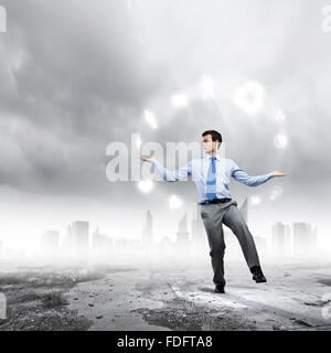 Junger Geschäftsmann Jonglieren mit konzeptionellen Symbole Hintergrund Stadt Stockfoto