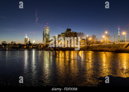 Ein Blick auf Gebäude in der Nähe der alten Donau in Wien. Im Winter bei Sonnenuntergang aufgenommen. Gefrorenen Eis auf dem See zu sehen. Stockfoto