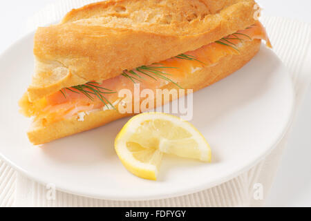 Nahaufnahme von frischem Lachs Sandwich auf weißen Teller und Tischset Stockfoto