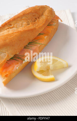 frischer Lachs Sandwich auf weißen Teller und Tischset Stockfoto