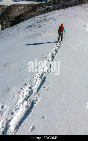 Frau in blau mit roten Rucksack, Schneeschuhwandern, französischen Pyrenäen Stockfoto