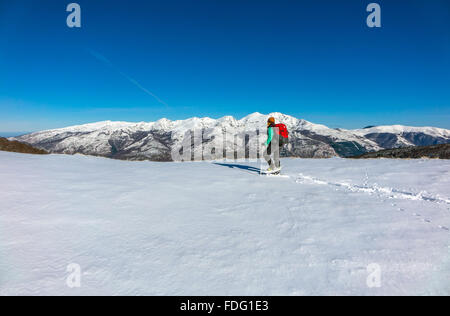 Frau in blau mit roten Rucksack, Schneeschuhwandern, französischen Pyrenäen Stockfoto
