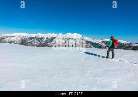 Frau in blau mit roten Rucksack, Schneeschuhwandern, französischen Pyrenäen Stockfoto