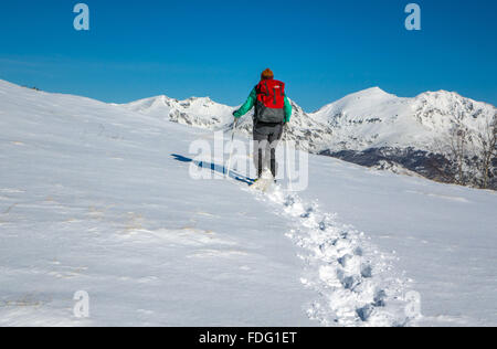 Frau in blau mit roten Rucksack, Schneeschuhwandern, französischen Pyrenäen Stockfoto