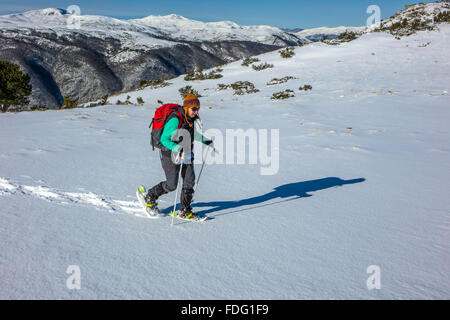 Frau in blau mit roten Rucksack, Schneeschuhwandern, französischen Pyrenäen Stockfoto