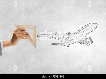 Nahaufnahme eines Menschen Hände Flugzeug Wih Lineal messen Stockfoto
