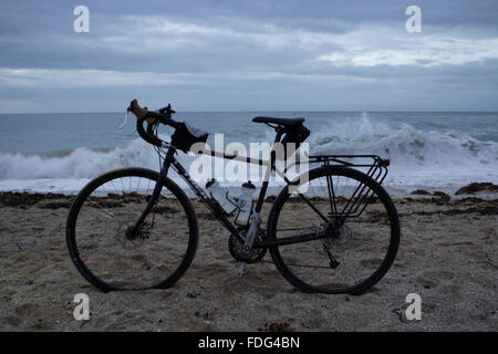 Ein Tourenrad auf Gyllyngvase Strand bei Sonnenaufgang Stockfoto