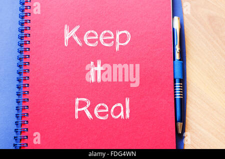 Keep it real Text Konzept schreiben auf Notebook mit Stift Stockfoto