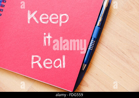 Keep it real Text Konzept schreiben auf Notebook mit Stift Stockfoto