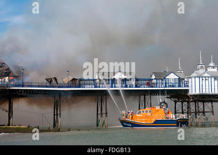 Ein Rettungsboot hilft gegen das Feuer ausgebrochenen auf den viktorianischen Pier in Eastbourne, East Sussex Stockfoto