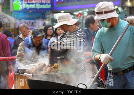 HONG KONG - 17 Dez., Hong Kong Hawker Süßkartoffeln auf Straße in Hongkong am 17. Dezember 2011 zu verkaufen. Stockfoto