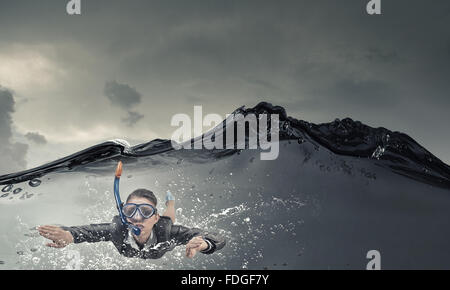 Junge Geschäftsfrau in Anzug und Taucherbrille Schwimmen unter Wasser Stockfoto