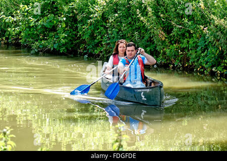 Ein junger Mann und eine Frau Kanu auf dem Kennet & Avon Kanal bei Bradford on Avon, Wiltshire, Vereinigtes Königreich. Stockfoto