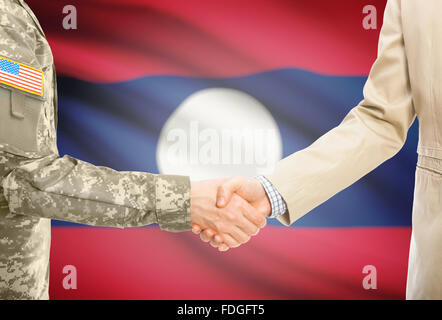 Amerikanische Soldaten in uniform und Zivil Mann im Anzug Händeschütteln mit Nationalflagge auf Hintergrund - Laos Stockfoto