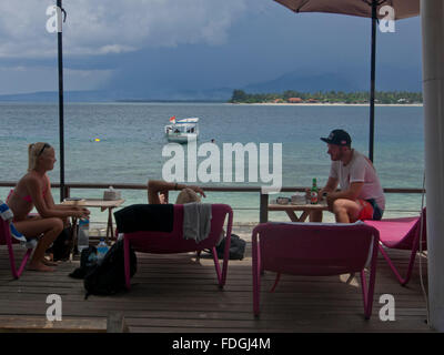 Touristen und traditionelle Boote am Strand von Gili Air Insel Lombok, Indonesien Stockfoto