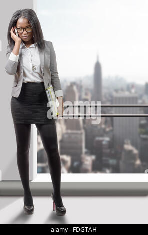 ein in voller Länge Portrait von einem afroamerikanischen Geschäftsfrau Lächeln am Telefon Stockfoto