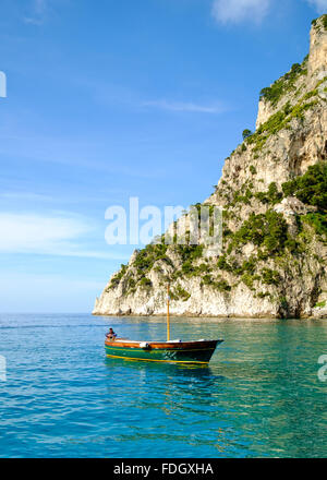 Ein Mann sitzt auf einem Boot vor der Insel Capri Stockfoto