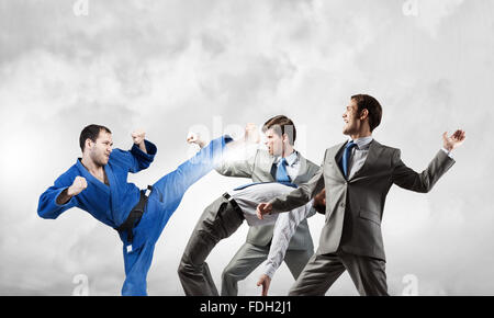 Junge bestimmt Karate-Mann Kampf mit Team der Unternehmer Stockfoto