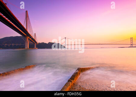 Hong Kong Brücken bei Sonnenuntergang über dem Ozean Stockfoto