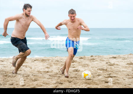 Junge Männer, die Fußball spielen, am Strand von St. Lucia, Kwazulu-Natal, Südafrika - iSimangaliso Wetland Park Stockfoto