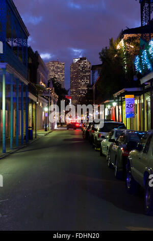 New Orleans French Quarter Street in der Nacht mit Hochhaus im Hintergrund Stockfoto