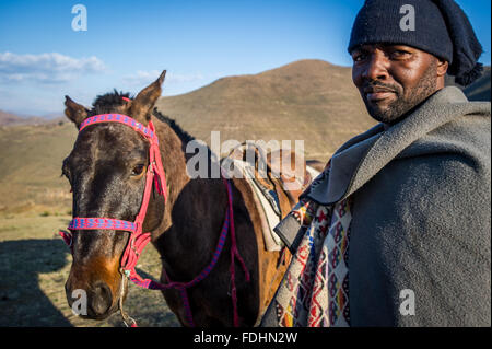 Porträt eines Mannes und sein Pferd vor einem Berg in Lesotho, Afrika Stockfoto