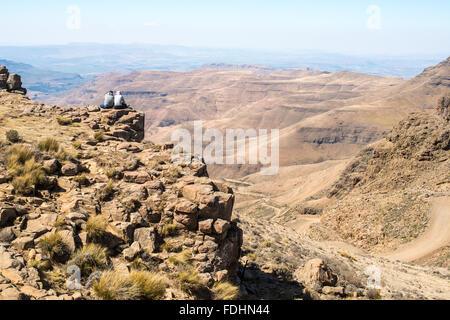 Zwei Menschen sitzen am Rand einer Klippe mit Blick auf die Berge in Lesotho, Afrika Stockfoto